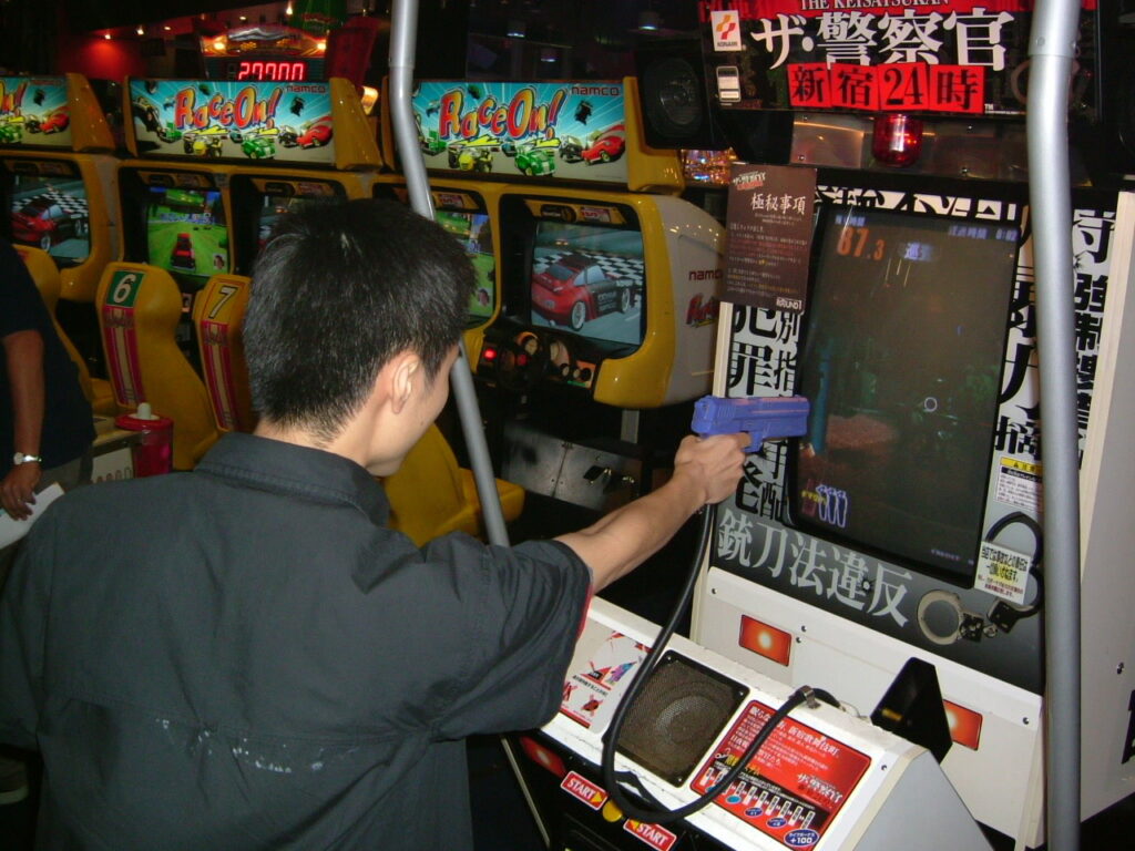 Man firing light gun at game arcade screen